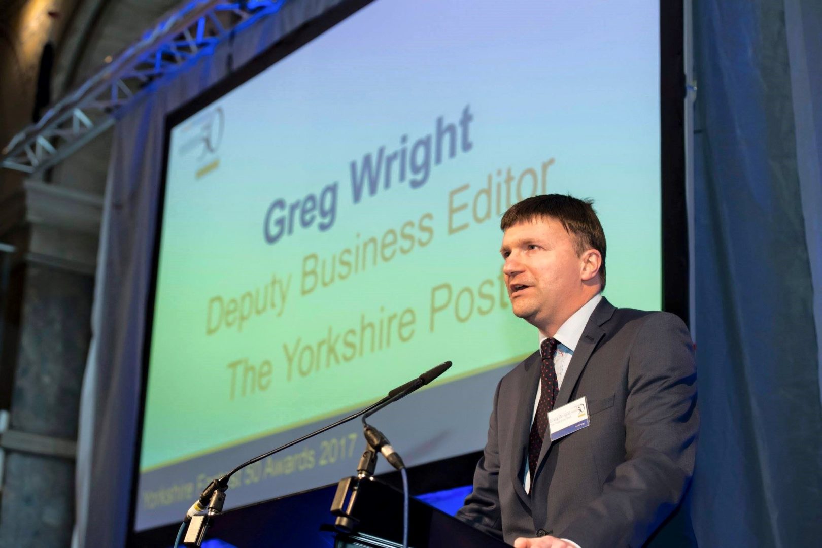Greg Wright, Business Editor at the Yorkshire Post, stands at a lectern speaking
