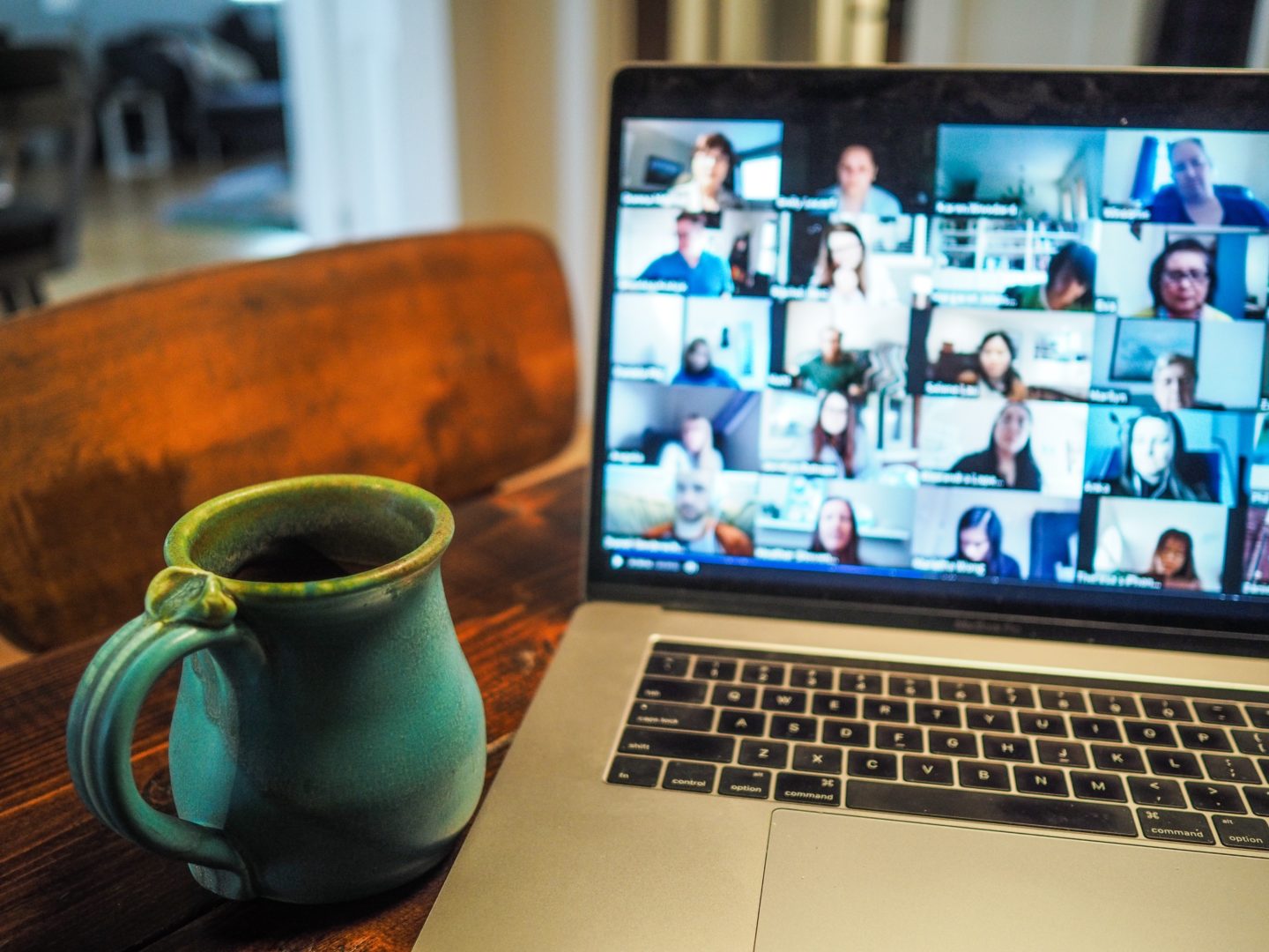 Home office set up showing a video call underway with a cup of coffee next to it