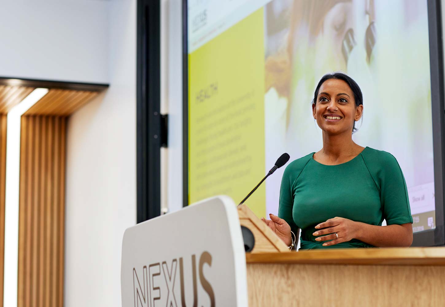 Female standing at lectern and presenting in the Nexus lecture theatre