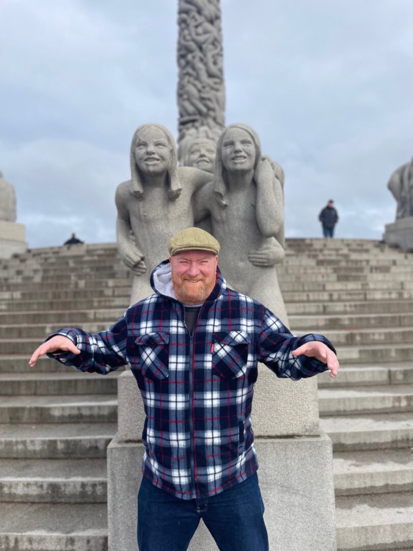 Barry Singleton in Oslo posing in front of statues.