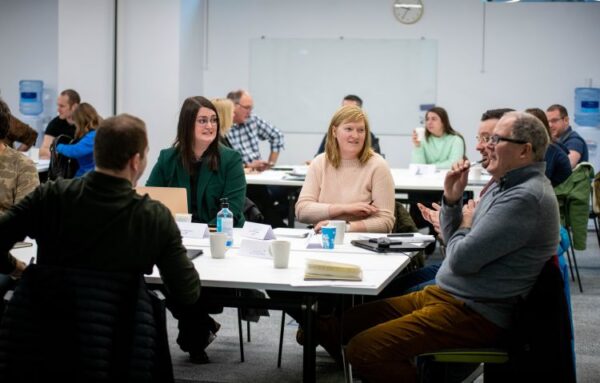 A group of people sat around a table discussing a project.