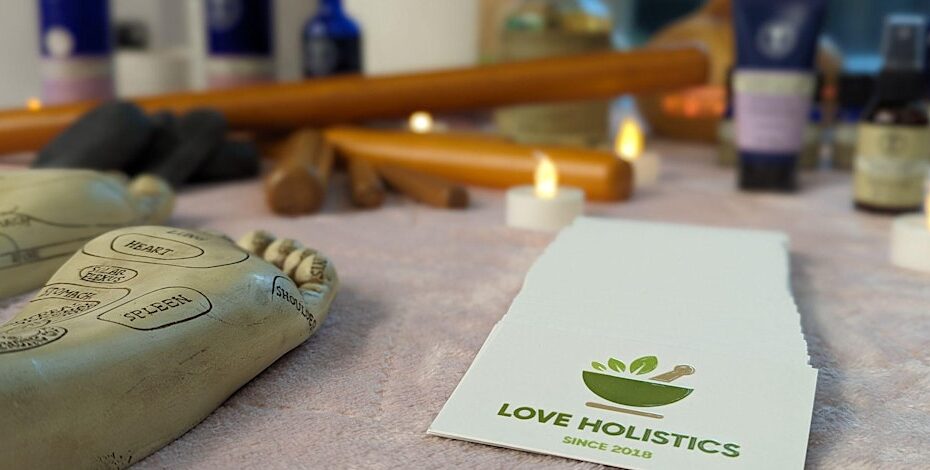 Love Holisitics logo surrounded by candles.