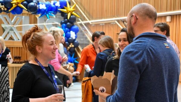 People at an event in conversation smiling