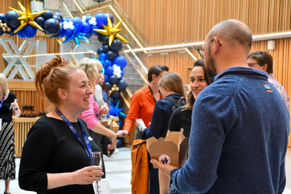 People at an event in conversation smiling