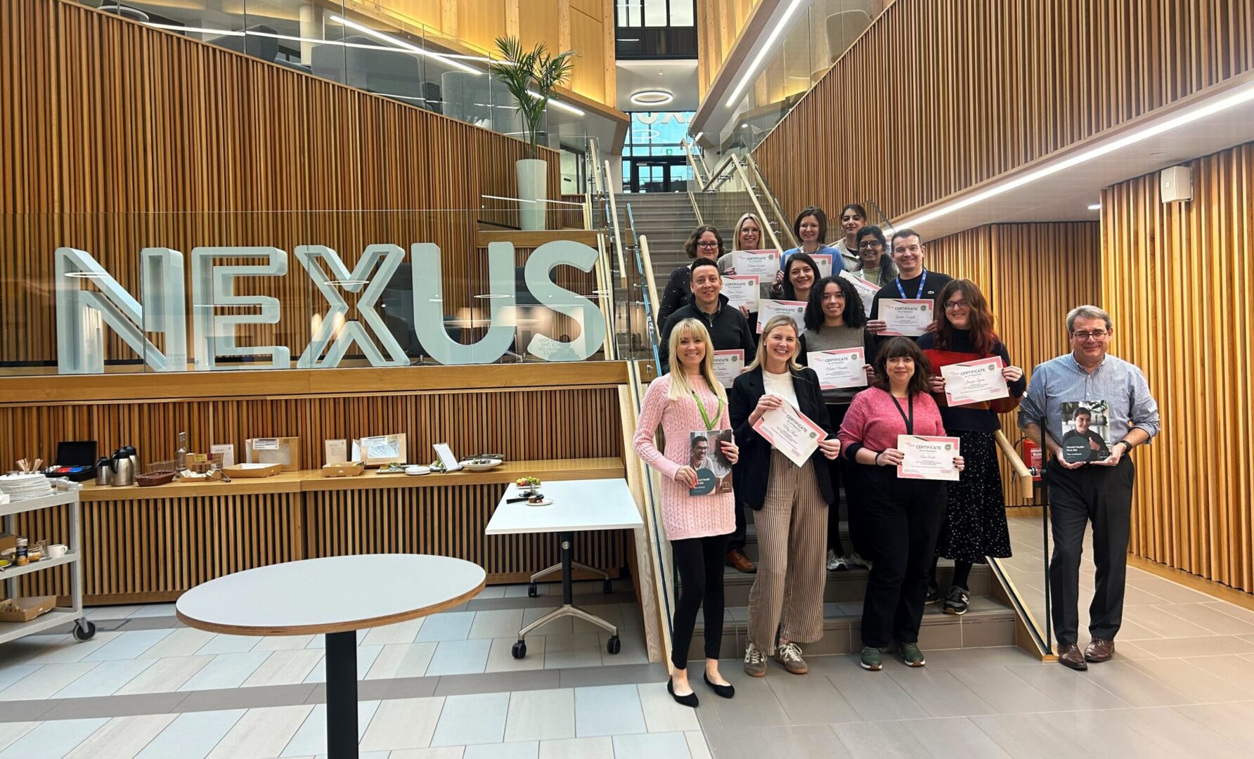 Nexus team members with Ellie MacDonald holding certificates for mental health training