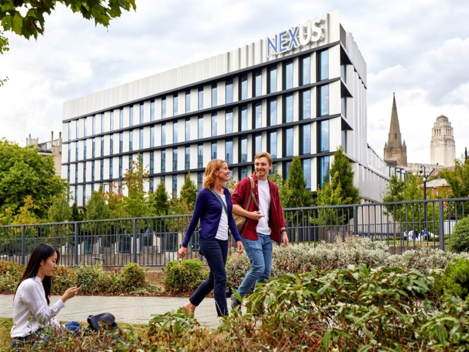 Two people walking in conversation outside of the Nexus building.