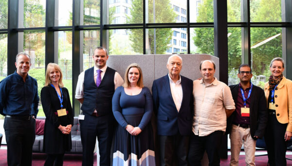 Image shows MOU participants stood in an office environment following the signing