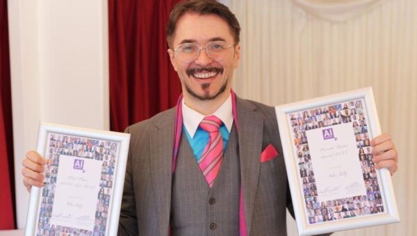 Giles Tully holding awards