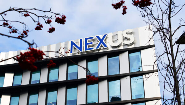 Nexus building with trees and berries in the frame and building behind