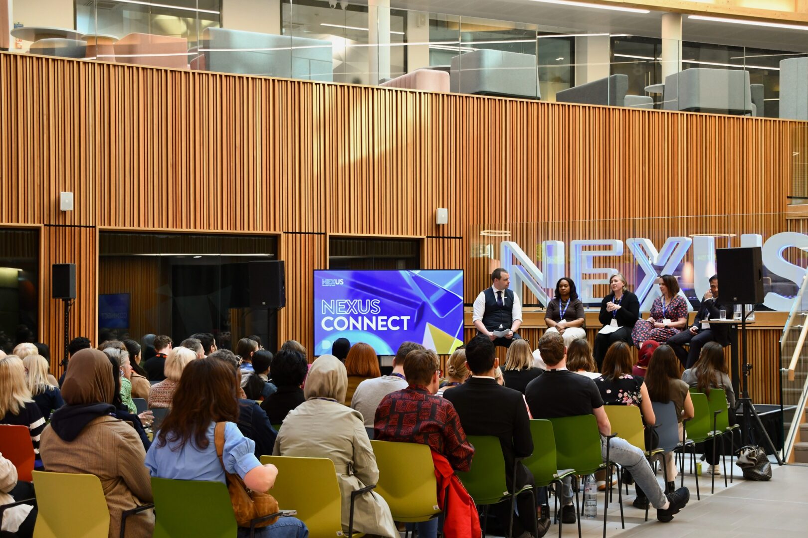 Seated group listening to Nexus Connect 15 panel