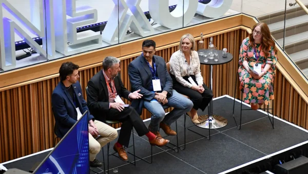 5 panelists sitting on a stage