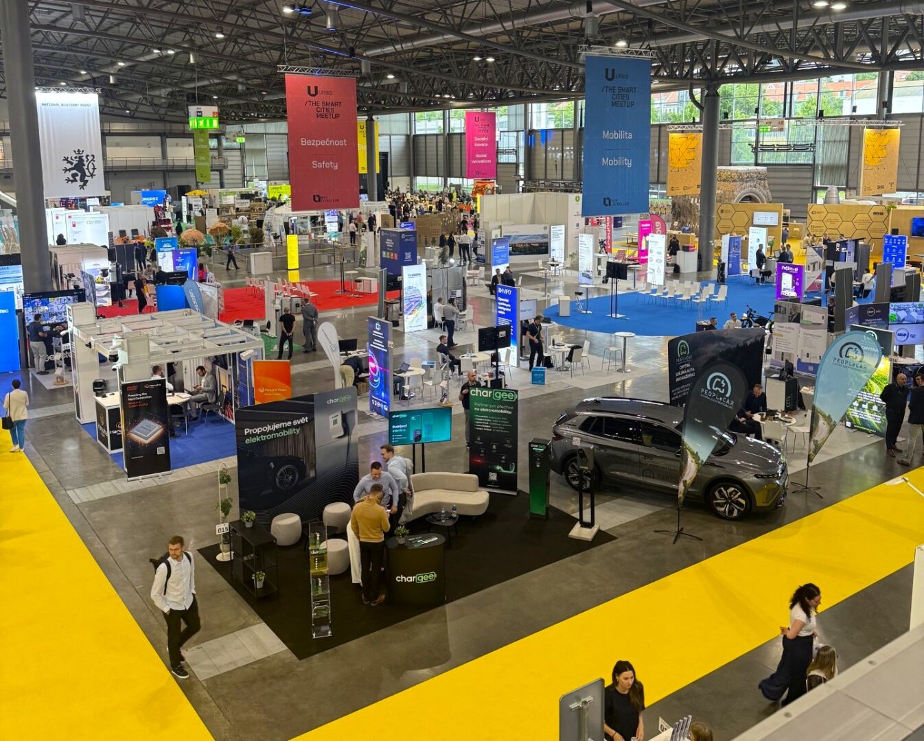 Many colourful stands with people walking between them.